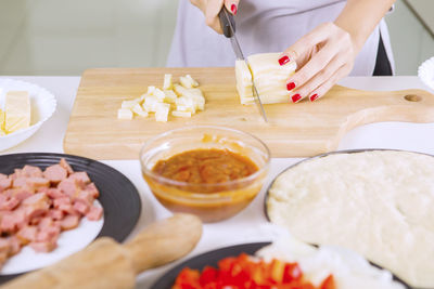 High angle view of woman preparing food on cutting board