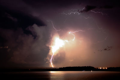 Firework display over calm sea at night