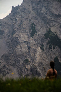 Rear view of shirtless man on rock