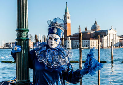 Woman wearing mask and costume against sea