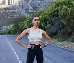 Portrait of young woman exercising on road