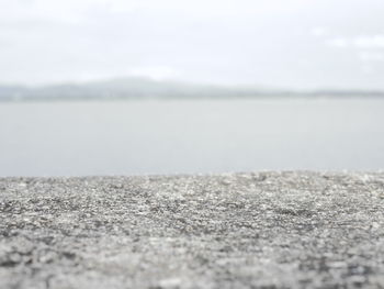 Close-up of pebbles on beach against sky