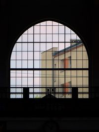 Silhouette building seen through glass window