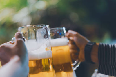 Cropped image of hand holding beer glass