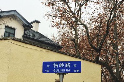 Low angle view of road sign against built structure