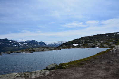 Scenic view of lake by mountains against sky