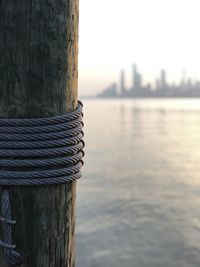 Close-up of wooden post in sea against sky