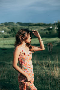 Side view of young woman standing on field