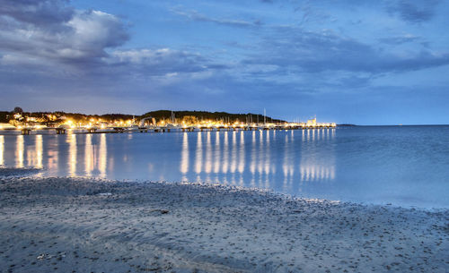 Scenic view of beach against sky at dusk