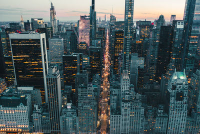 Aerial view of illuminated buildings in city at dusk