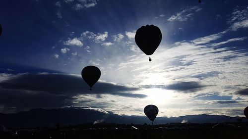 Silhouette hot air balloon against sky