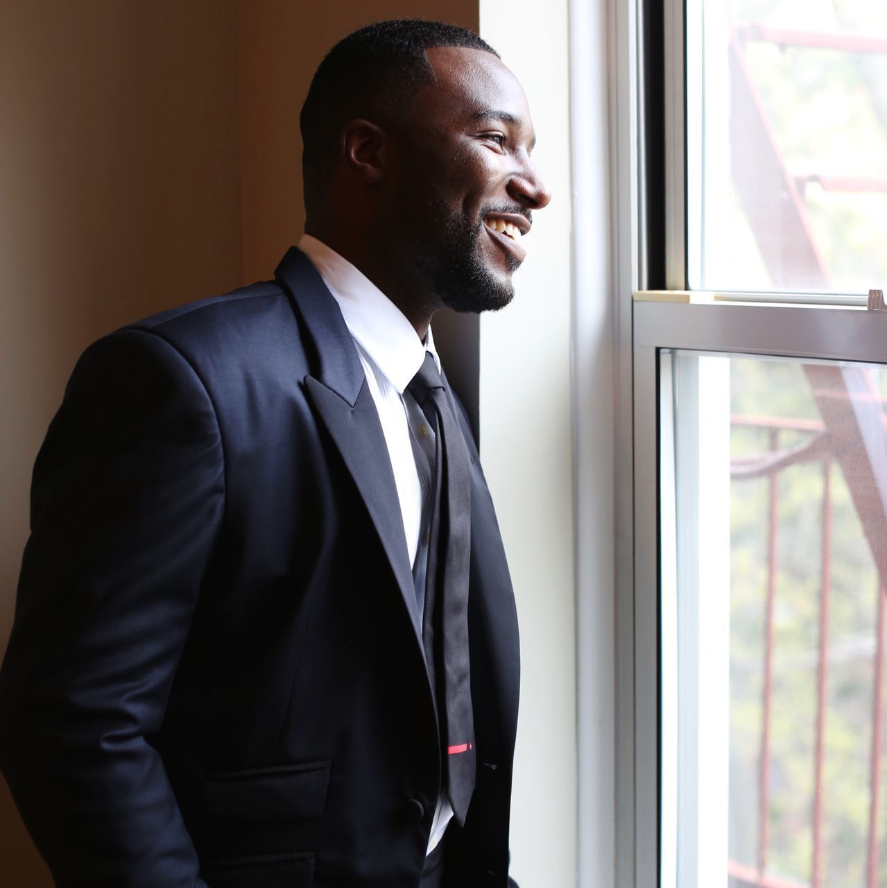 businessman, business, suit, well-dressed, one person, full suit, window, corporate business, indoors, standing, young adult, men, real people, office, smiling, day