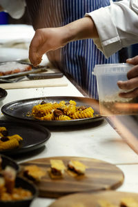 Midsection of chef preparing food on table