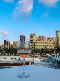 Wine glass in city against sky