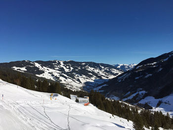 Scenic view of snowcapped mountains against clear blue sky