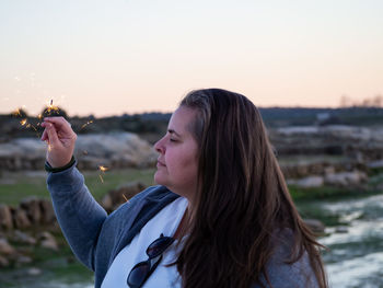 Portrait of woman standing against sky during sunset