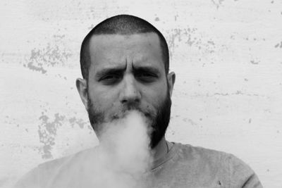 Portrait of man exhaling smoke