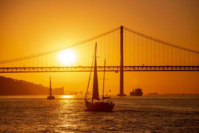 Low angle view of suspension bridge at sunset