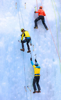 Rear view of people ice climbing