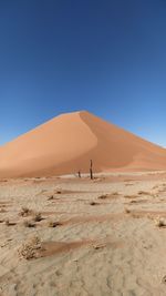 Scenic view of desert against clear blue sky