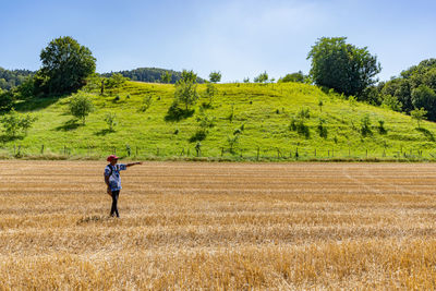 Full length of woman standing on field against sky