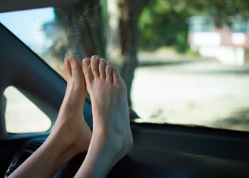 Low section of woman sitting in car