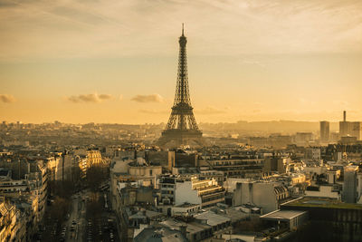 Aerial view of buildings in city against cloudy sky