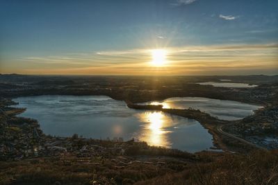 Aerial view of city at waterfront during sunset