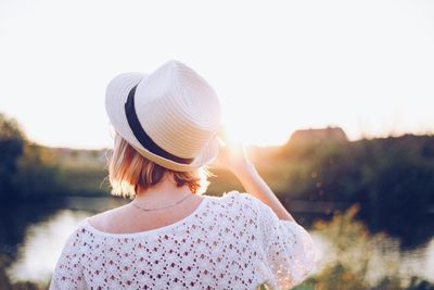 Rear view of woman with hat standing against sky