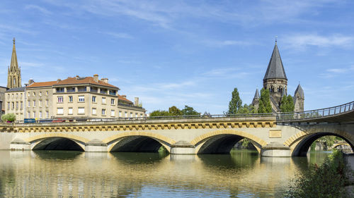 Arch bridge over river against buildings in city