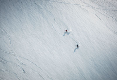 Two men skiing on snow in iceland from overhead angle