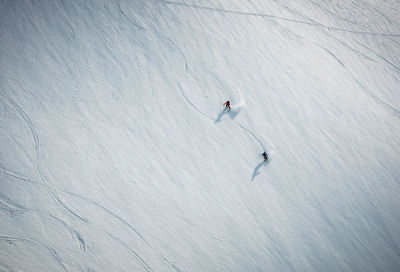Two men skiing on snow in iceland from overhead angle