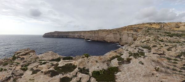 Coastal cliffs in round bay with dark blue water in gozo, malta.