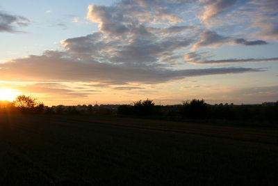 Scenic view of field against sky at sunset