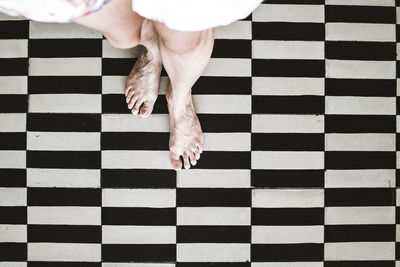 Low section of man walking on patterned floor