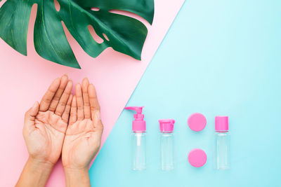 Close-up of hand holding pink over white background