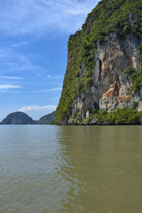 Scenic view of sea by mountains against sky