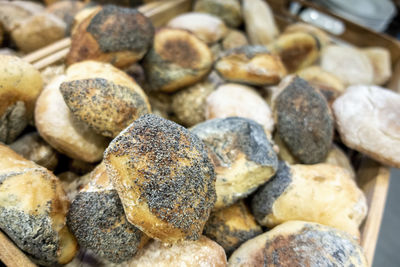 Baked bread buns with poppy seeds topping in serving tray. angled view for a unique perspective.