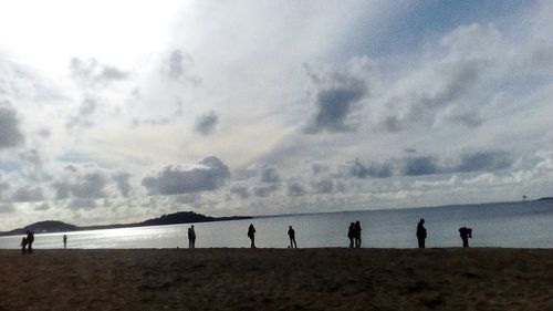 People on beach against sky