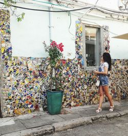 Full length of woman standing by building