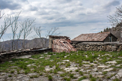 Abandoned house on field against sky