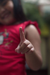 Midsection of girl gesturing while standing outdoors