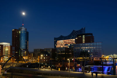 Illuminated cityscape against sky at night