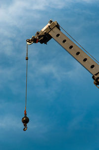 Low angle view of crane against blue sky