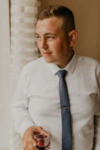 Portrait of young man drinking glass