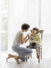 Mother giving hair cut to son at home