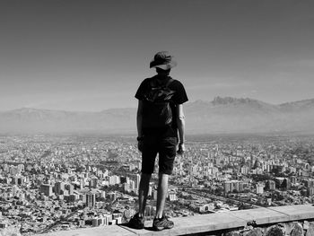 Full length of woman standing by cityscape against sky