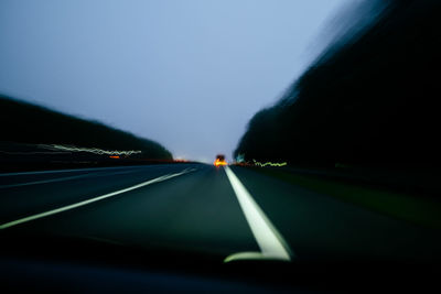 Blurry view on nightly road with red car lights