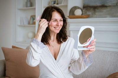 Woman using face roller. sculpting, lifting and anti-aging care. skin care