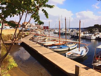 Boats moored at harbor against sky